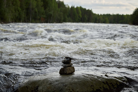 A Beautiful Serene River Landscape Featuring a Collection of Balancing Stones Artistically Arranged