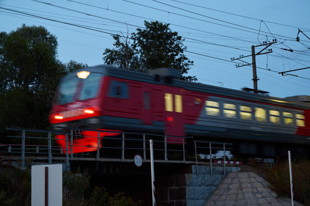 A Blurry Train Moving Swiftly Through a City Landscape at Dusk During the Evening Hours