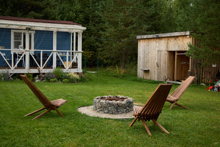 Enjoy a cozy outdoor fire pit with comfortable chairs and a charming cabin in tranquility