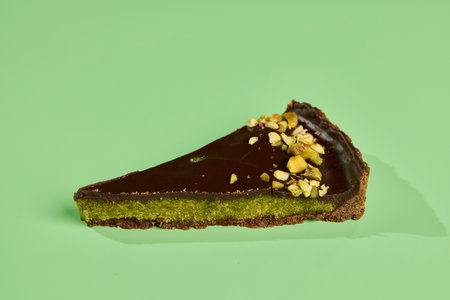 Enjoy a decadent Chocolate Pistachio Tart, beautifully presented on a vibrant green background