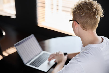 A Young Professional is Actively Working on Their Laptop