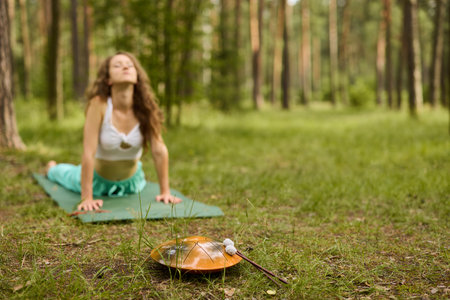 Engaging in Yoga Practice amidst the Beauty of Nature while Playing the Handpan Musical Instrument