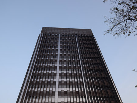 A stunning modern office building rises majestically against a beautifully clear sky