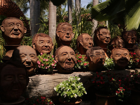 An Artistic Garden Display featuring a Variety of Creative and Unique Face Plantersの写真素材