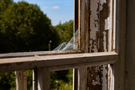An Abandoned Window Featuring Broken Glass Set Within a Rustic and Charming Environment