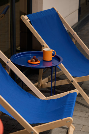 Charming Outdoor Seating Area Featuring Beautiful Blue Deck Chairs and a Refreshing Drink