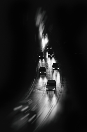Cars driving in the rain, black and white, night photography, urbanの写真素材