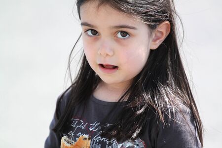 Little girl eating cake with chocolateの写真素材