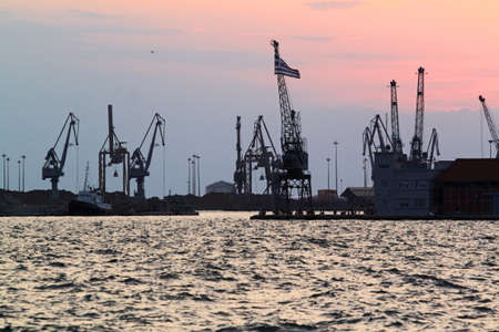 Thessaloniki, Greece - August 09, 2015: Panoramic view cargo ships port in the export and import business and logistics international goods at sunset.のeditorial素材