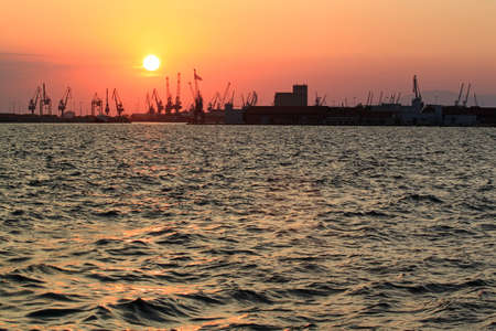 Thessaloniki, Greece - August 09, 2015: Panoramic view cargo ships port in the export and import business and logistics international goods at sunset.のeditorial素材