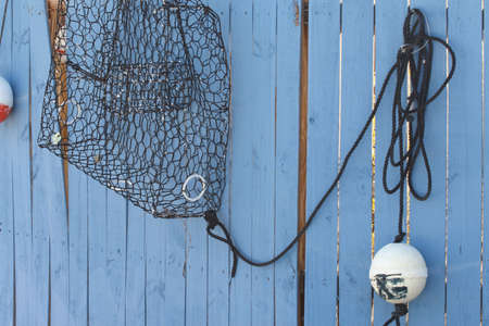 Crab and lobster trap on wooden wall and marker buoyの写真素材