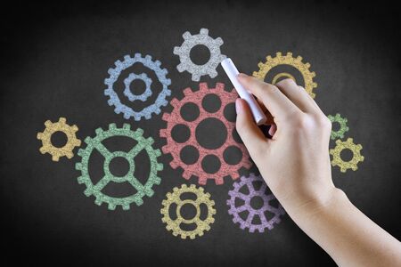 Hand drawing cog gears on blackboardの写真素材