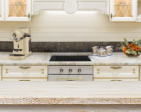 Wooden textured table over blurred kitchen stove interior backgroundの写真素材