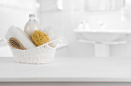 White basket with spa products on wooden table inside bathroomの写真素材