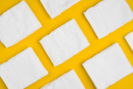 White clean soft folded towels arranged on yellowの写真素材