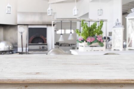 Wooden table top on blurred modern restaurant kitchen room