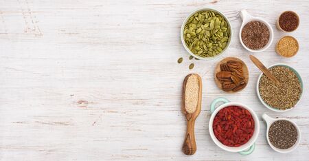 Different seeds, cereals, beans, nuts and berries on wooden backgroundの写真素材