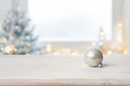 Xmas ball on table in front of defocused festive backgroundの写真素材