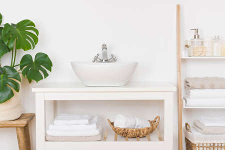 Sink in bathroom with towels and spa products on shelvesの写真素材
