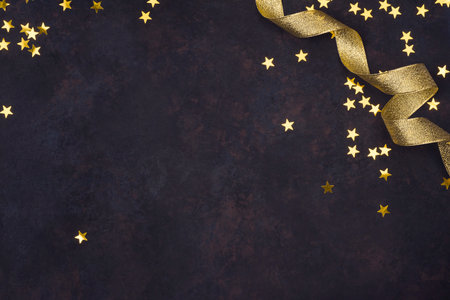 Abstract holiday background with golden stars confetti and curled ribbonの写真素材