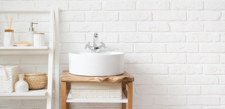 Bathroom sink and ladder shelf on white brick wall backgroundの写真素材