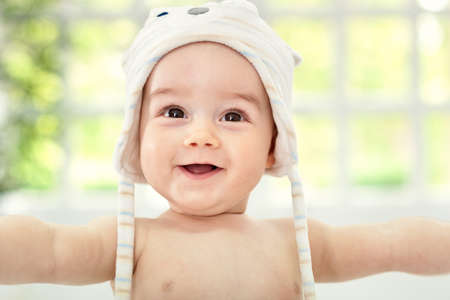 Smiling happy baby with cute hatの写真素材