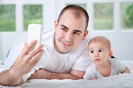 Father and son looking to phone and taking selfie