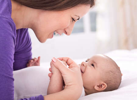 Beautiful mother smiling and playing with her baby
