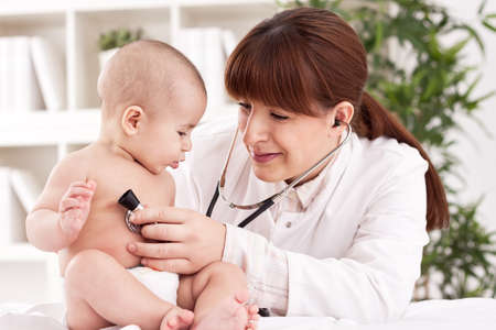 The female doctor examining baby with stethoscope
