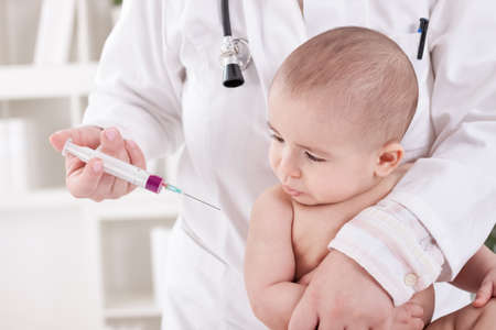 Doctor giving a child a vaccine in shoulderの写真素材
