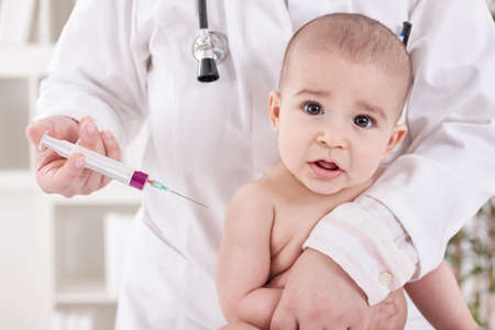 Suprised baby child needs to receive vaccineの写真素材