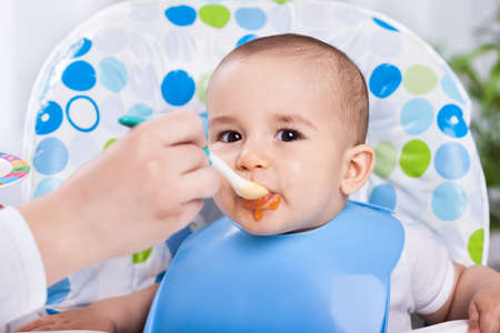 Dirty cute baby enjoy when eating food in kitchenの写真素材