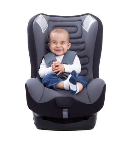 Funny cute baby sitting in a car seat, isolated on whiteの写真素材