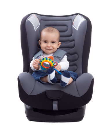 Adorable little kid sitting in a car seat, isolatedの写真素材