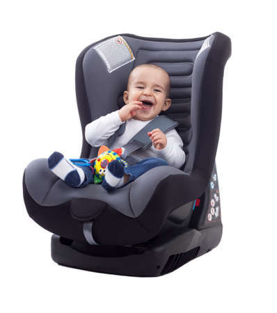 Adorable smiling happy child sitting in a car seat, isolatedの写真素材