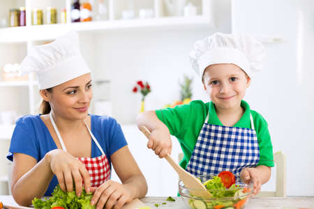Mom and kid cooking together in kitchenの写真素材
