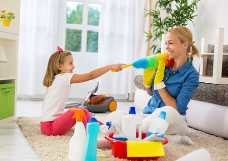 Happy family funny moments when cleaning homeの写真素材