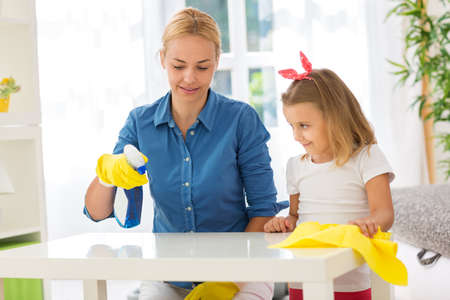 Mother and cute child cleaning table with mopの写真素材