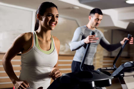 Young beautiful couple working out cardio training at gym