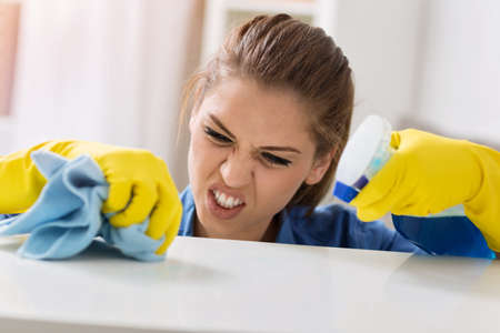 Persistent girl cleaning the table with mop