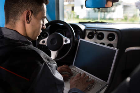Mechanic check the electronics with laptop, looking diagnostic problemの写真素材