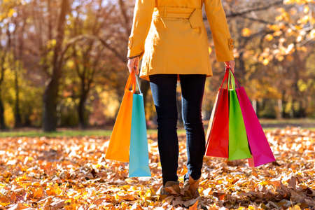 Woman holding colorful shopping bags, autumn conceptの写真素材