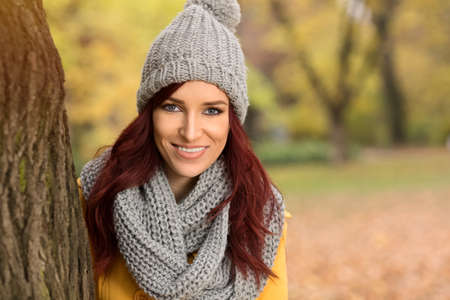 Happy smiling woman with a gray cap at autumn parkの写真素材