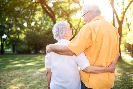 Happy and handsome senior couple hugging in parkの写真素材