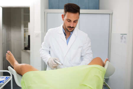 Young professional gynecologist exam his patient at clinicの写真素材