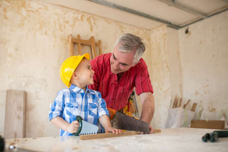 Working fun grandfather and grandson in a carpenter's workshop, family conceptの写真素材