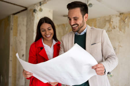 Happy loving looking blueprints of their home, closeupの写真素材