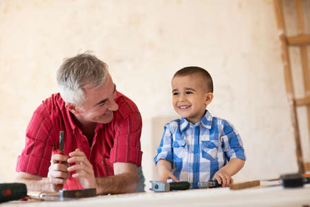 Grandfather and grandson in workshop, close upの写真素材