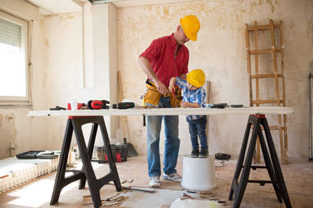 Worthy grandfather and grandson in a carpenter's workshop, closeup