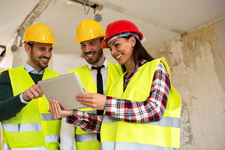 Group of young arhitects withl tablet on siteの写真素材